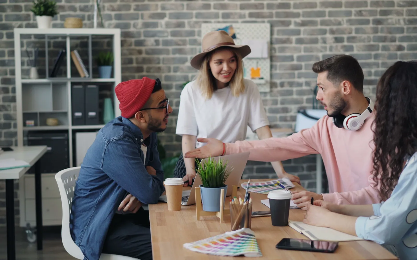 A team talking over color swatches and notes at a shared office table