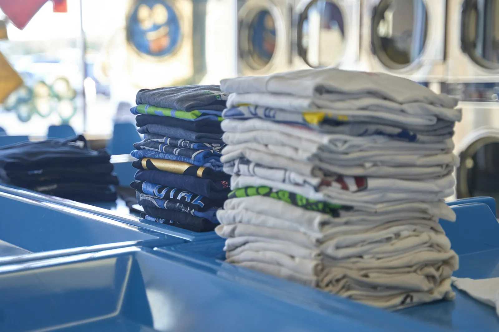 Stacks of folded printed t-shirts on a counter