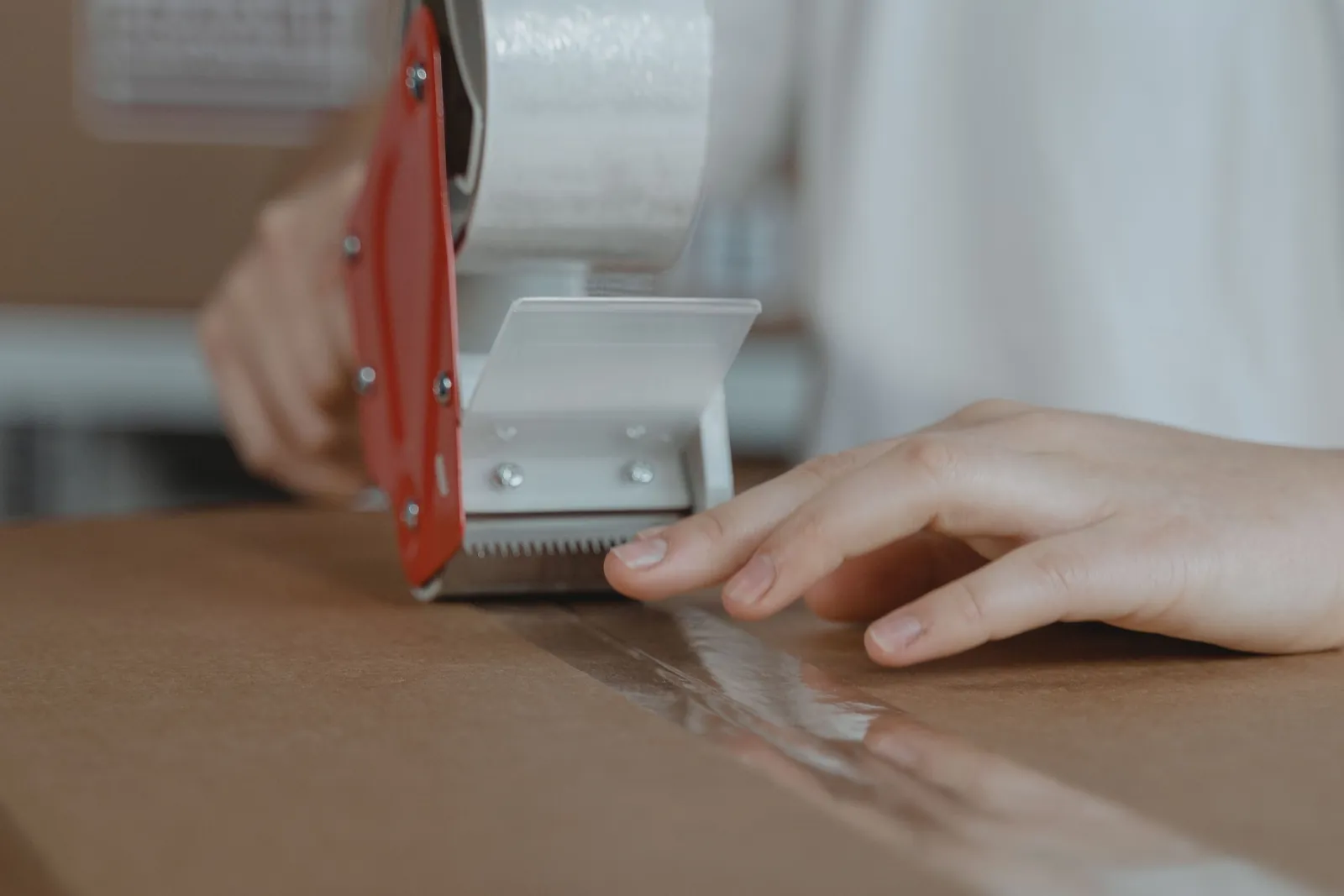 Sealing a cardboard box with a packing tape dispenser