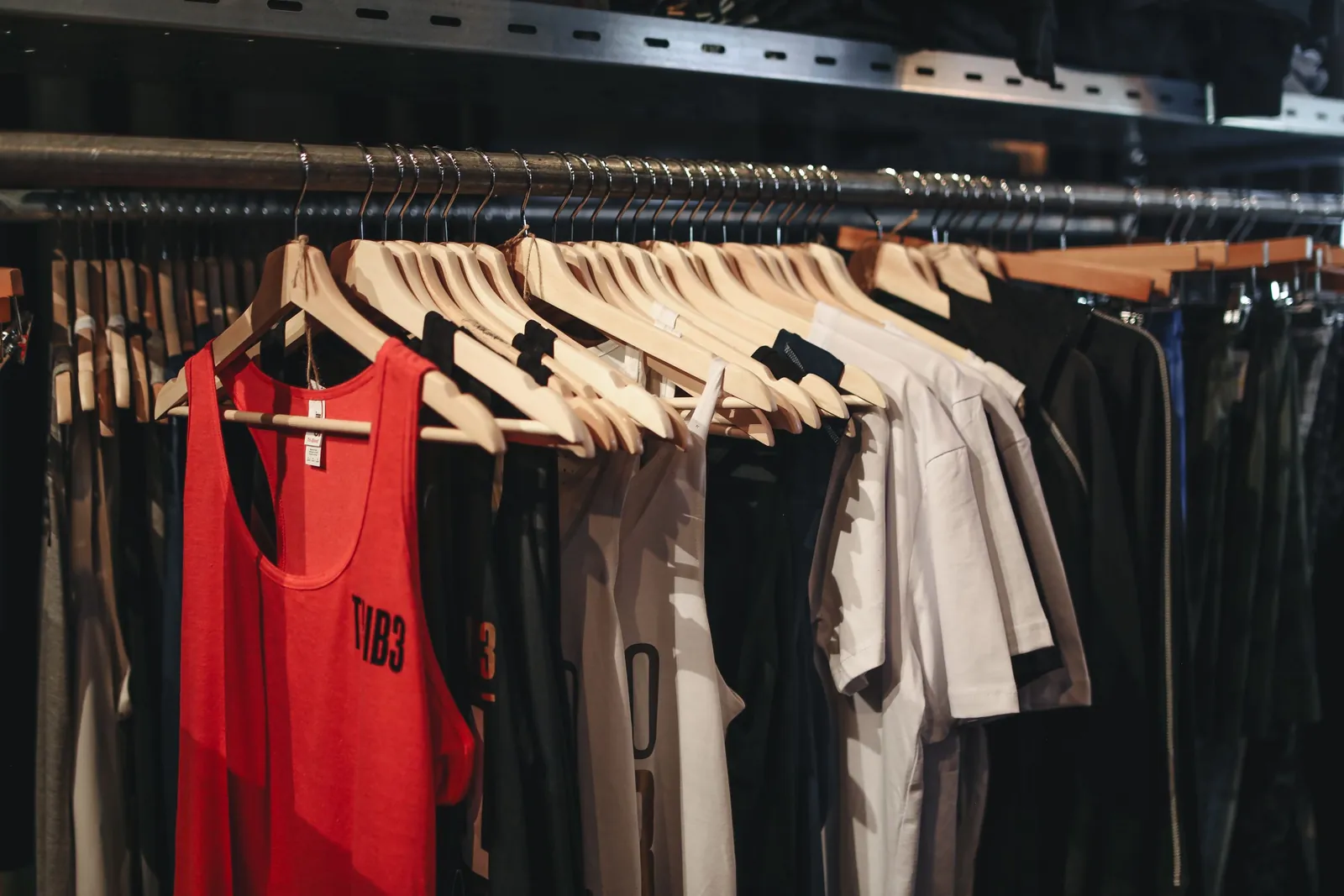 A rack of shirts and tank tops in mixed sizes in a clothing store