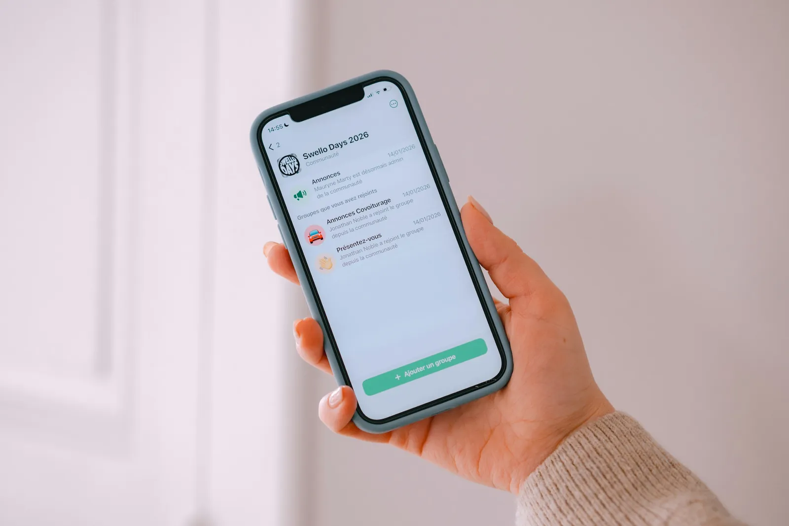 A hand holding a smartphone with a business app open on the screen